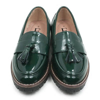 A pair of glossy dark green patent leather tassel loafers with chunky brown and black platform soles, shown from a top-down view on a white background.