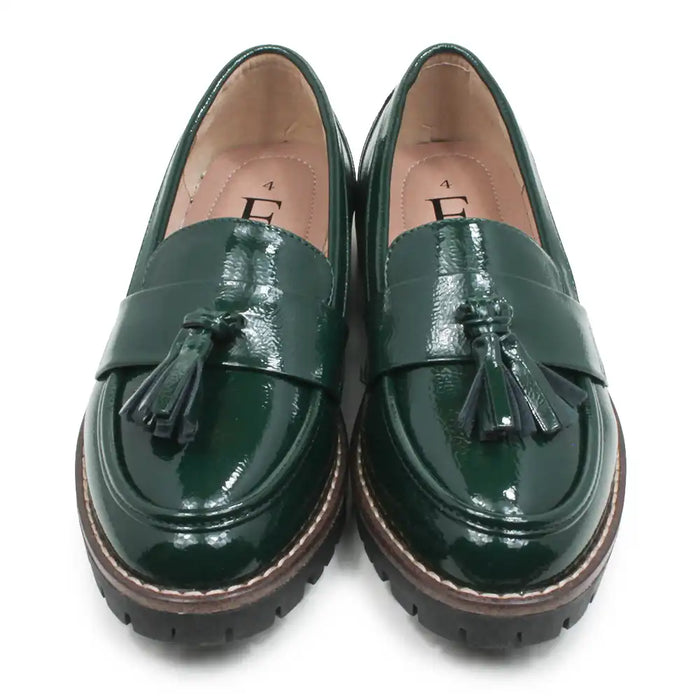 A pair of glossy dark green patent leather tassel loafers with chunky brown and black platform soles, shown from a top-down view on a white background.