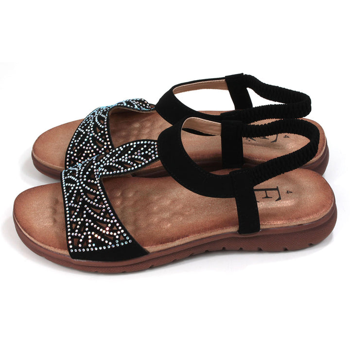 Black sandals decorated with diamantes. Elasticated black ankle strap. Tan, molded insoles. Side view.