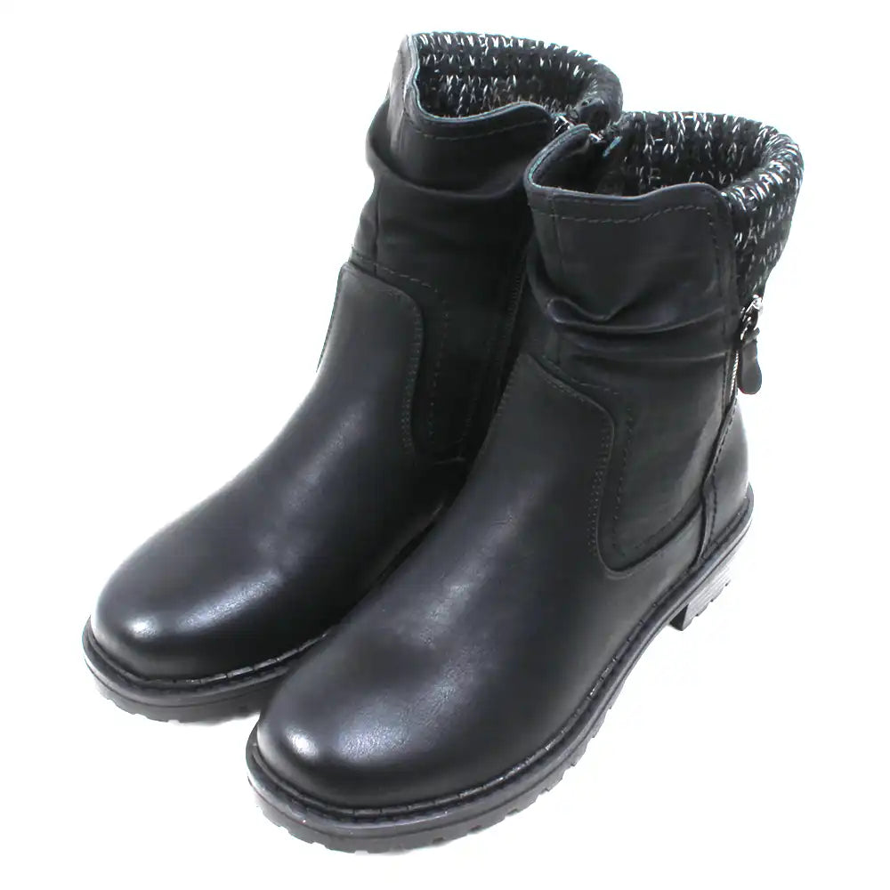 Black leather look ankle boots with grey and white knitted ankle cuffs. Low heels. Angled view.