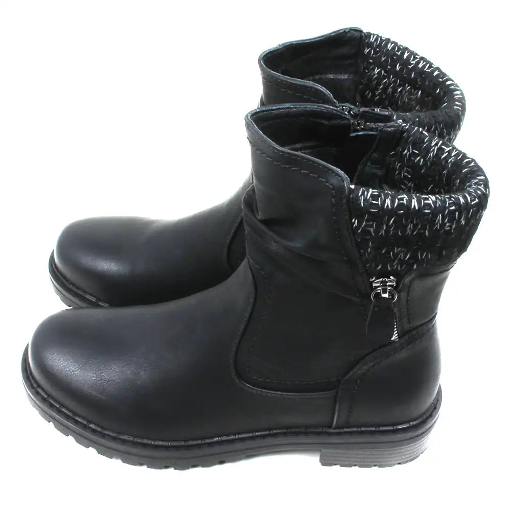 Black leather look ankle boots with grey and white knitted ankle cuffs. Low heels. Side view.