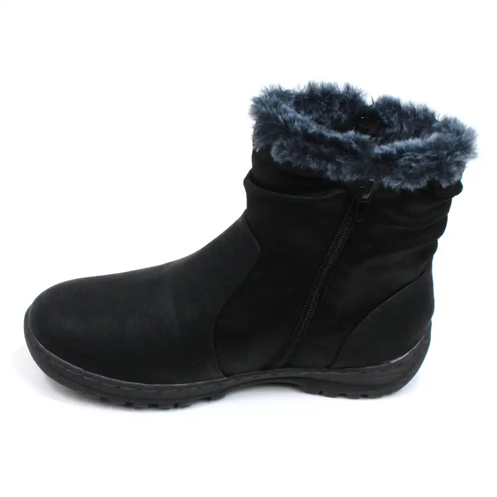 Black ankle boots by Shoes By Emma. Faux silver zips on the outside with fitting black zips on the inside of the feet and ankles. Grey fur cuffs around the ankle. Almost flat wedged soles. View of single boot showing the black fitting zip.