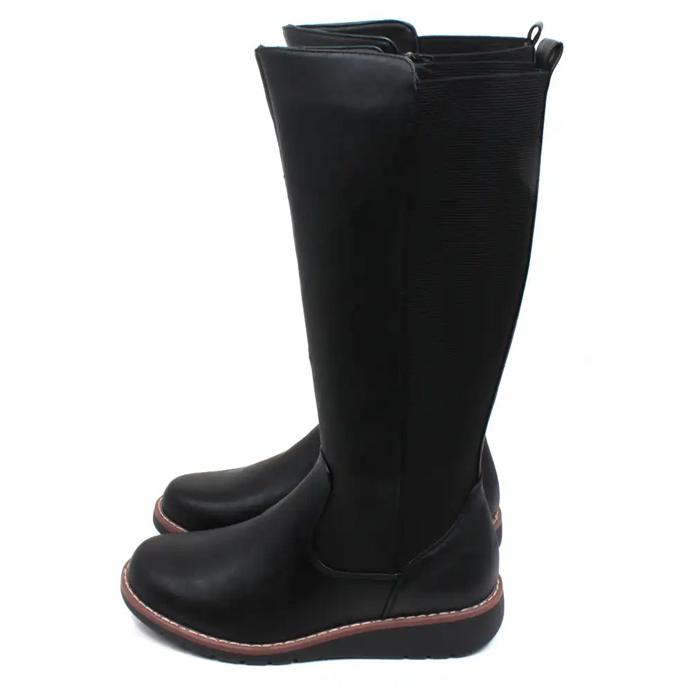 Shoes by Emma long length boots with low wedge soles. Black man made leather look materials. Elasticated panel down the back.  Zip fastening. Side view.