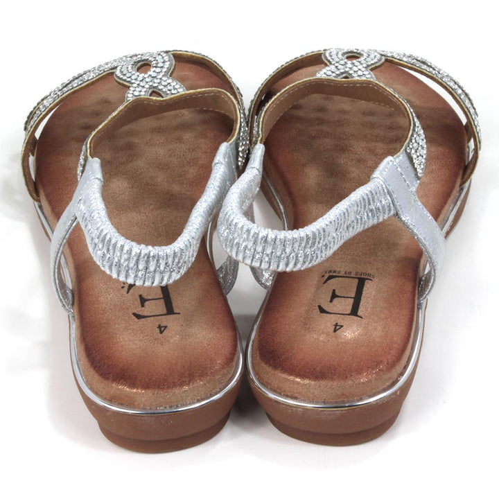 Silver, diamante covered sandals. Silver elasticated ankle straps. Tan coloured insoles. Silver trim around the soles. Back view.