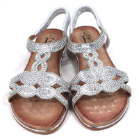 Emma silver, diamante covered sandals. Silver elasticated ankle straps. Tan coloured insoles. Silver trim around the soles. Front view.