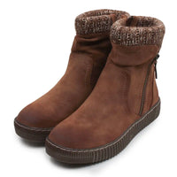 A pair of brown suede ankle boots with a ribbed sole, side zipper, and a patterned knit cuff, shown on a white background.