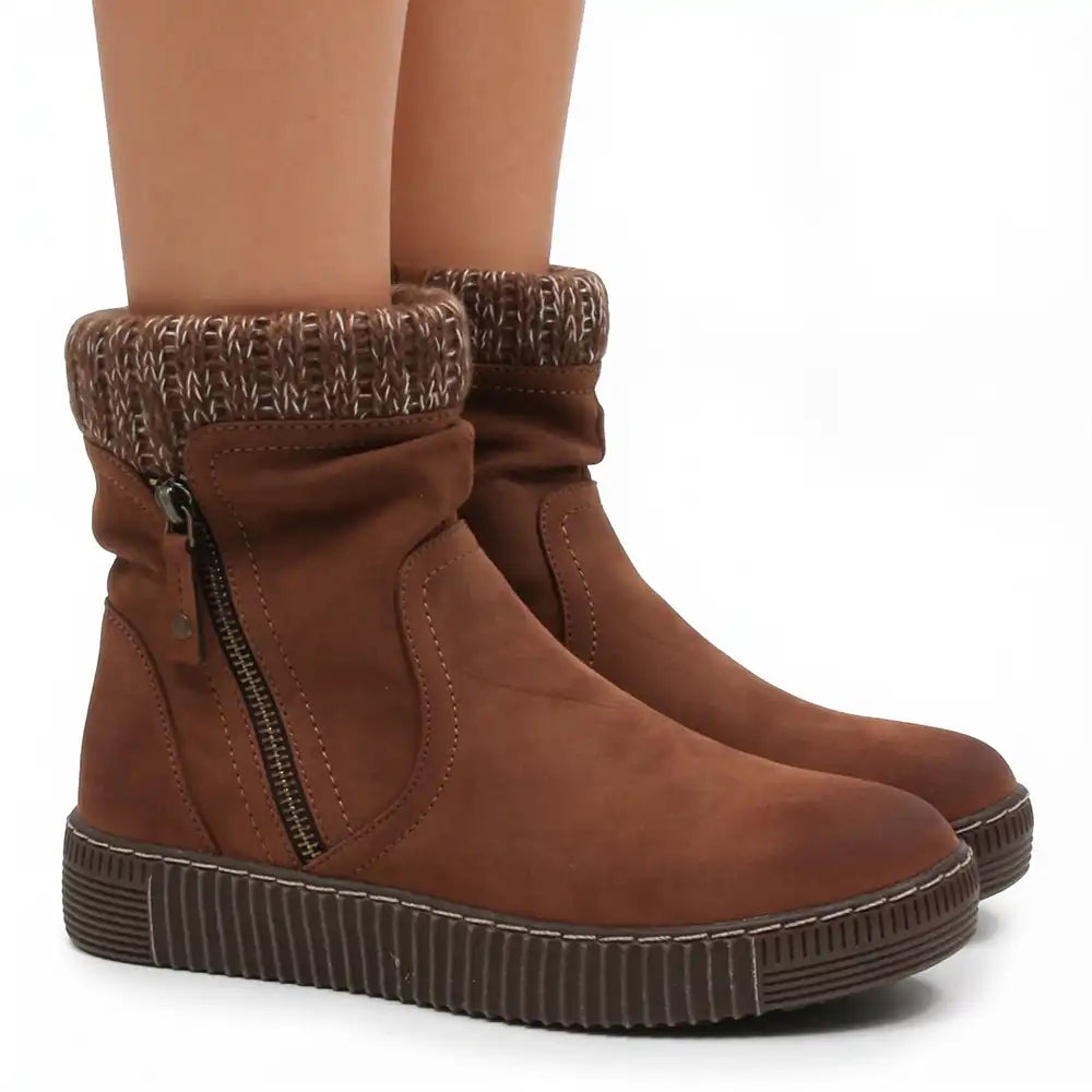 A pair of women's brown ankle boots with a knit-textured cuff and side zipper, shown on a model's feet against a white background.