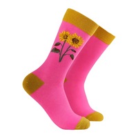 Pink socks with yellow sunflower design and mustard yellow accents on a white background