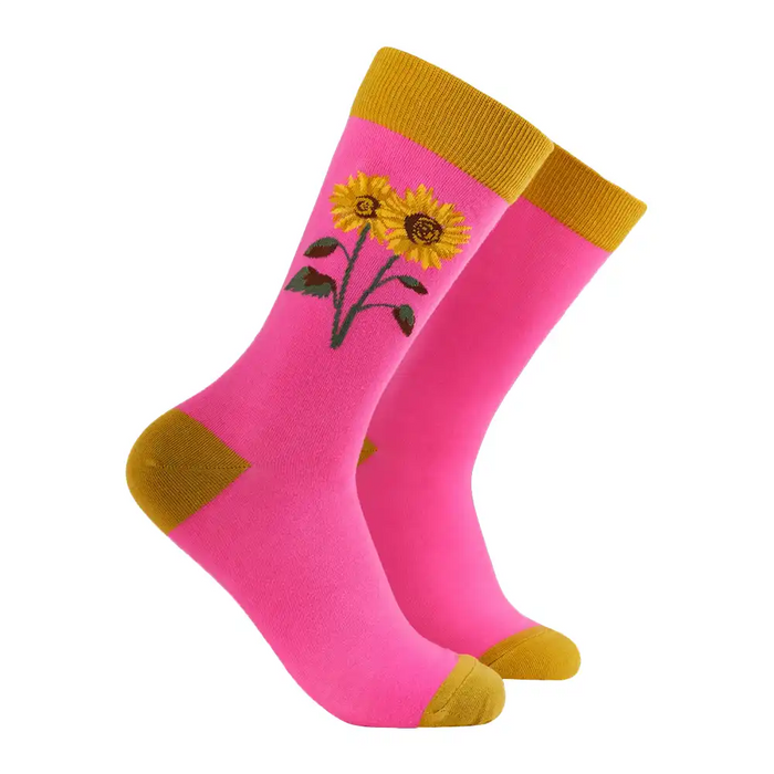 Pink socks with yellow sunflower design and mustard yellow accents on a white background