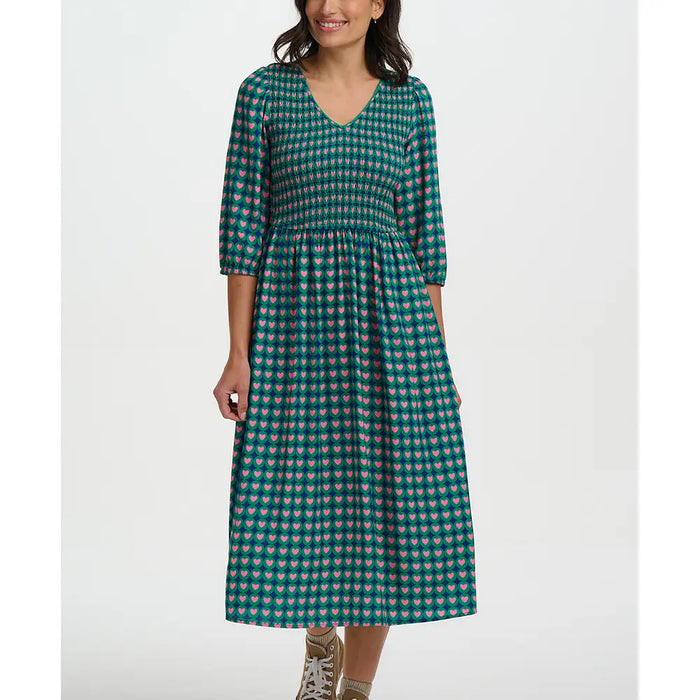 Woman wearing a green patterned dress on a white background