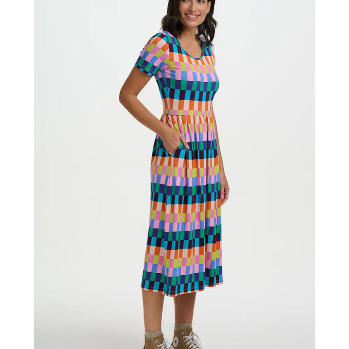 Woman wearing a colorful checkered dress on a white background