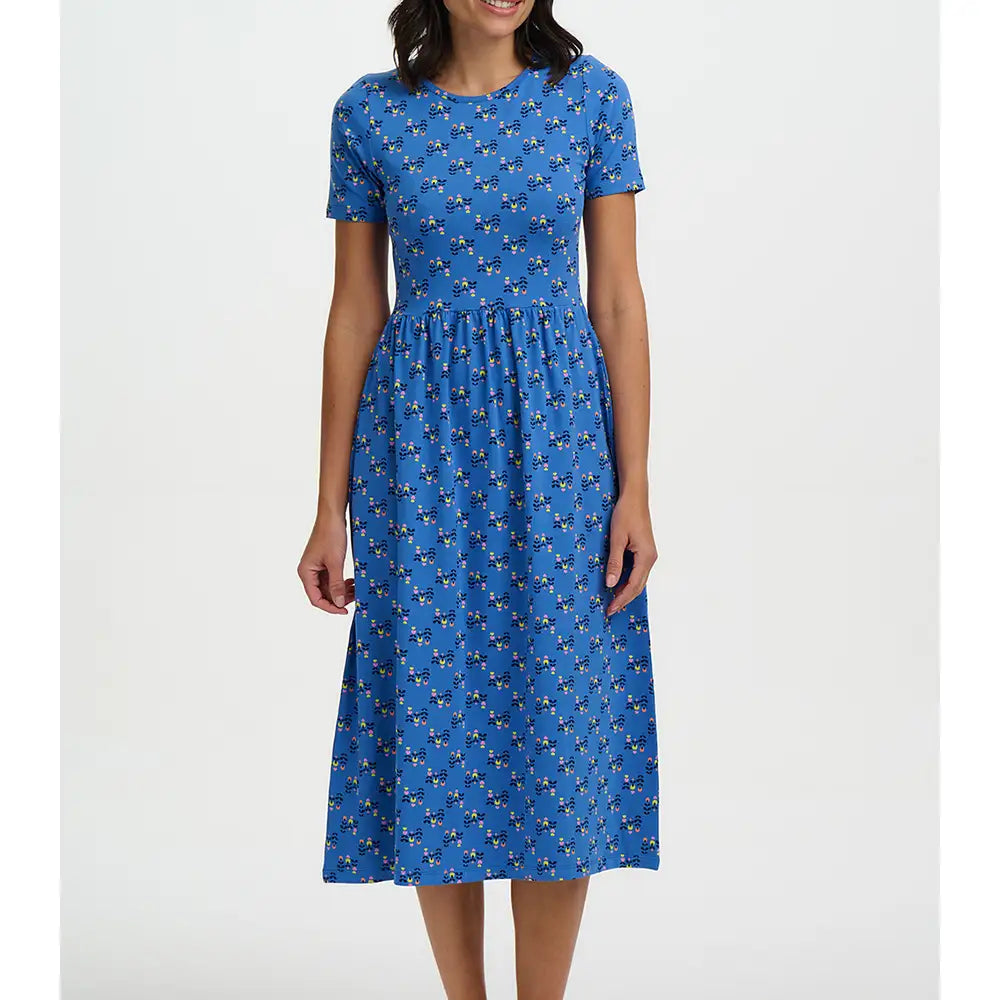 Woman wearing a blue dress with a pattern on a white background