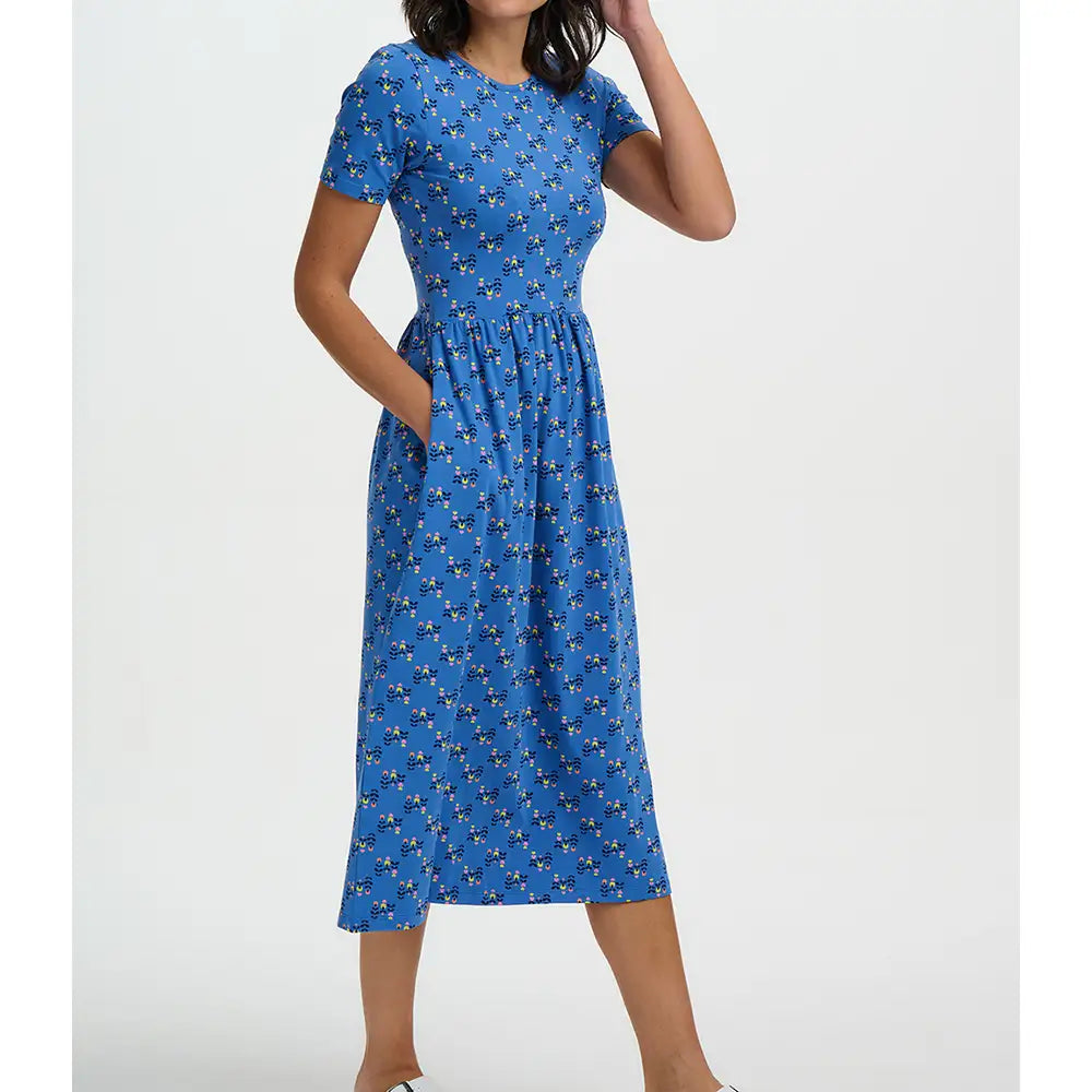Woman wearing a blue dress with a pattern on a white background