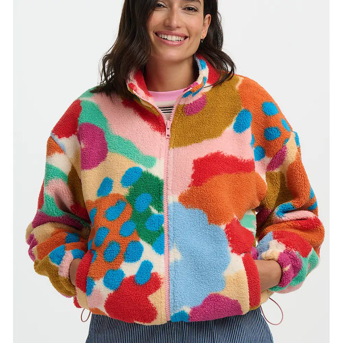 Woman wearing a colorful patterned jacket on a white background