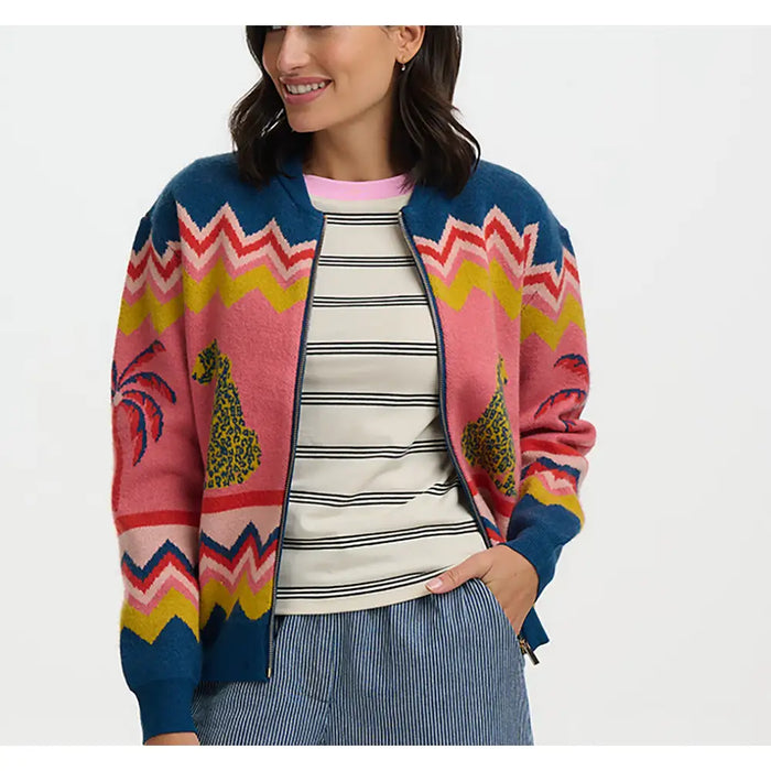 Woman wearing a colorful patterned cardigan over a striped shirt on a white background