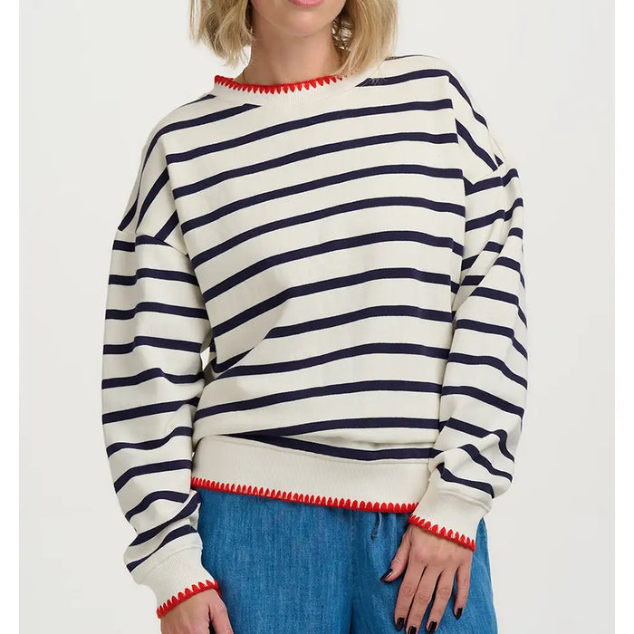 Person wearing a striped sweater with red trim on a white background