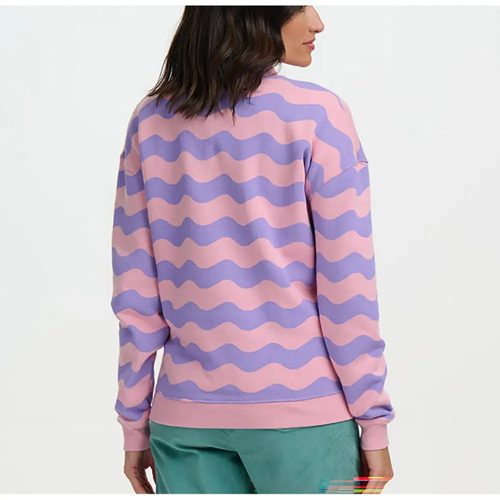 Person wearing a pink and purple wavy patterned sweater on a white background