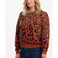 Woman wearing a brown sweater with colorful leopard print pattern on a white background