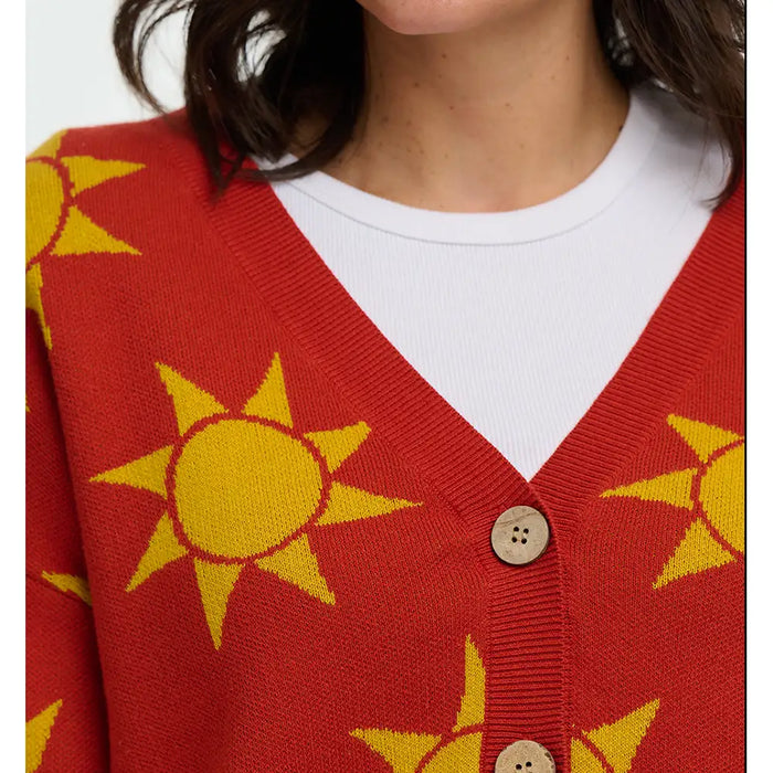 Red cardigan with yellow sun patterns worn by a person