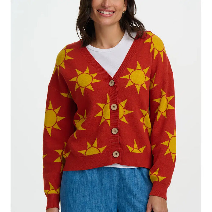 Person wearing a red cardigan with yellow sun patterns on a white background