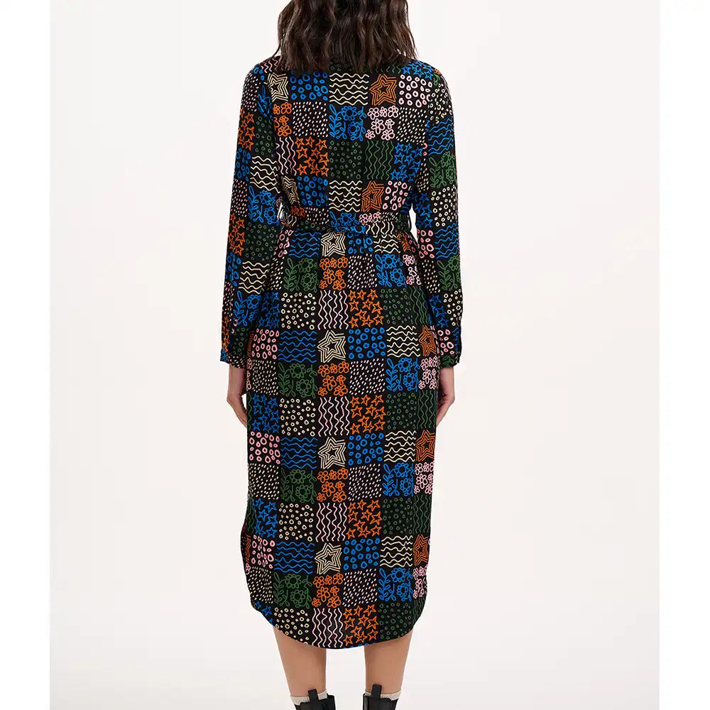 Multicolored patterned dress worn by a person on a white background