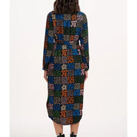 Multicolored patterned dress worn by a person on a white background