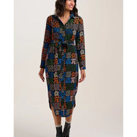 Woman wearing a patterned dress on a plain background