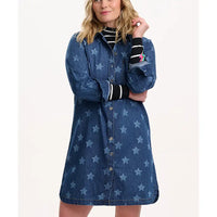 Woman wearing a blue denim dress with star pattern on a white background