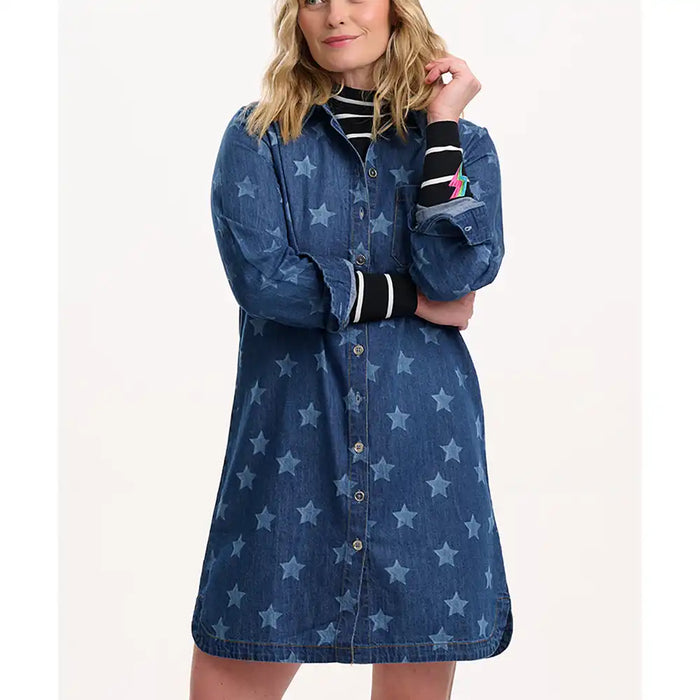 Woman wearing a blue denim dress with star pattern on a white background