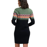 A woman shown from the back wearing a long-sleeve knit dress with a sage green upper section, a multicolor geometric pattern band, and a solid black lower body, set against a plain light gray background.
