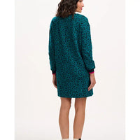 Woman wearing a teal patterned dress on a white background