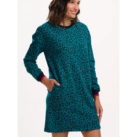 Woman wearing a teal patterned dress on a white background