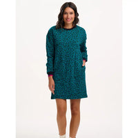 Woman wearing a teal patterned dress on a white background