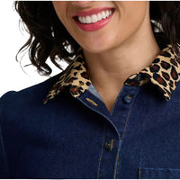Close-up of a person wearing a dark blue denim-style button-up shirt with a leopard-print collar.