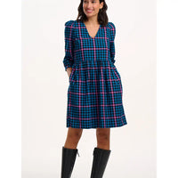 Woman wearing a blue and pink plaid dress with long sleeves on a white background