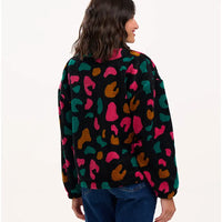 Person wearing a colorful patterned shirt on a white background