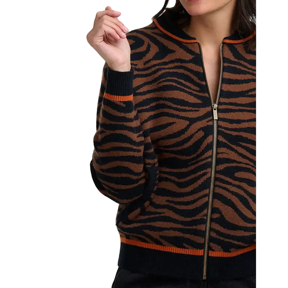 Woman wearing brown and black tiger print bomber jacket in a white studio environment.