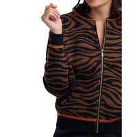 Woman wearing brown and black tiger print bomber jacket in a white studio environment.