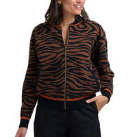 Woman wearing brown and black tiger print bomber jacket in a white studio environment.