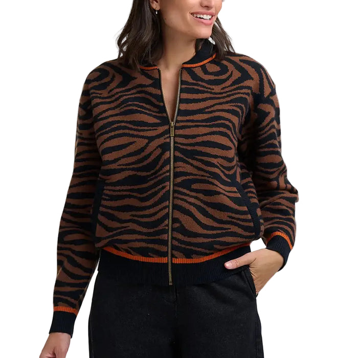 Woman wearing brown and black tiger print bomber jacket in a white studio environment.