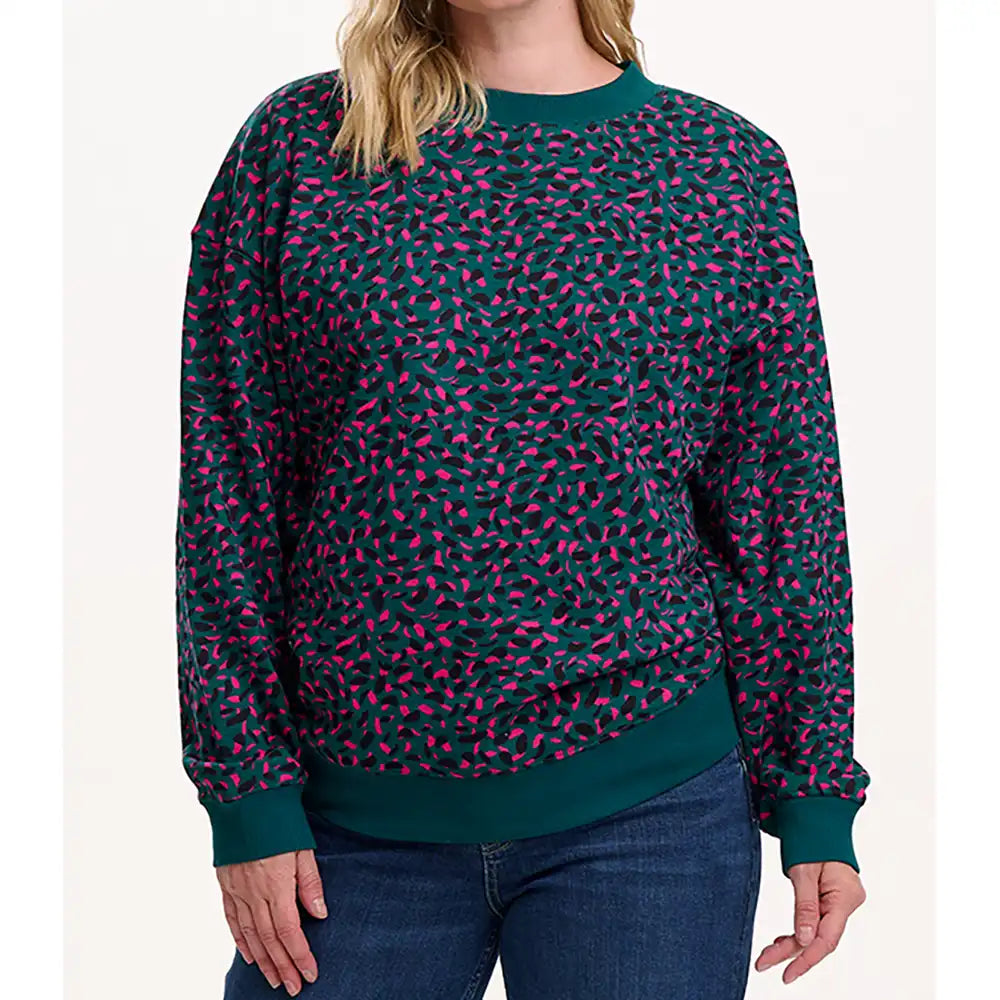 Person wearing a green and pink patterned sweater on a white background