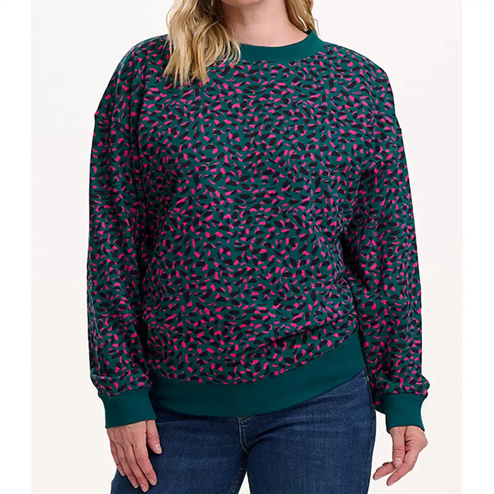 Person wearing a green and pink patterned sweater on a white background