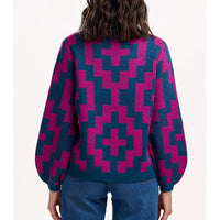 Person wearing a blue and pink geometric patterned sweater on a white background
