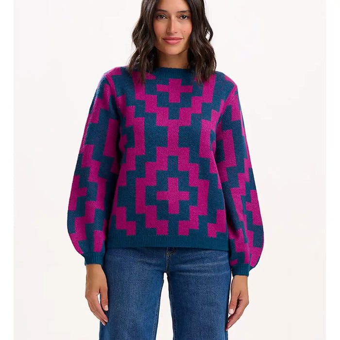 Woman wearing a blue and pink patterned sweater on a white background