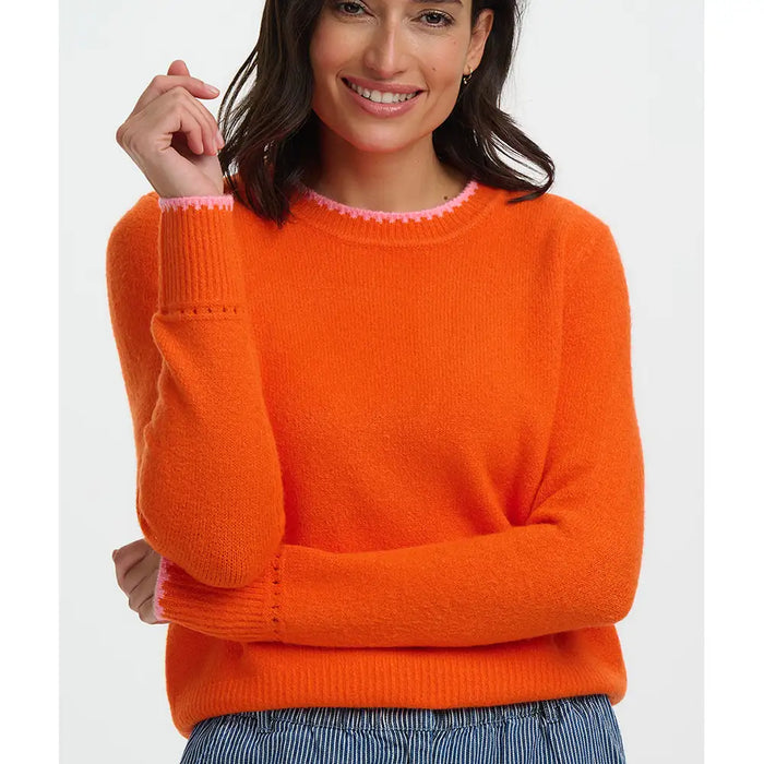 Woman wearing an orange sweater with a white background