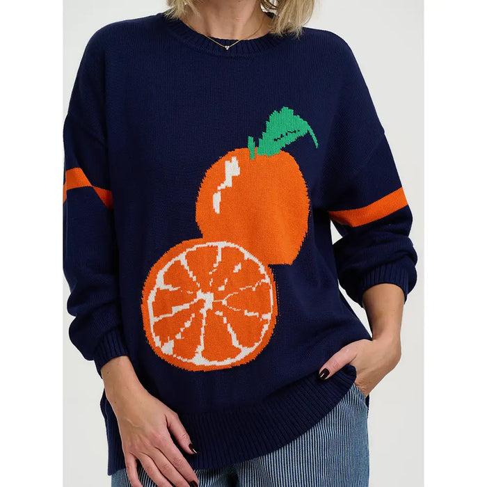 Navy sweater with orange and slice designs on a plain background