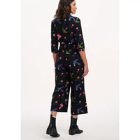 Woman wearing a black floral jumpsuit on a white background