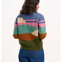 Person wearing a colorful sweater with landscape design on a white background