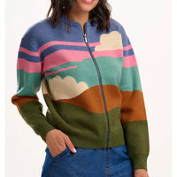 Colorful sweater with landscape design worn by a person on a white background