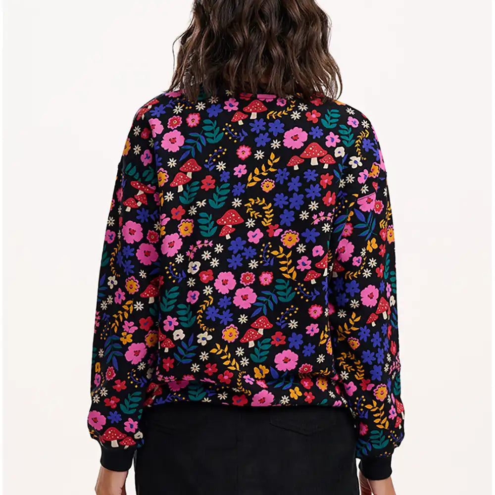 Person wearing a colorful floral-patterned jacket on a white background